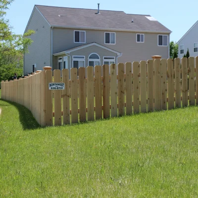 spaced wood fence wrapping around a backyard